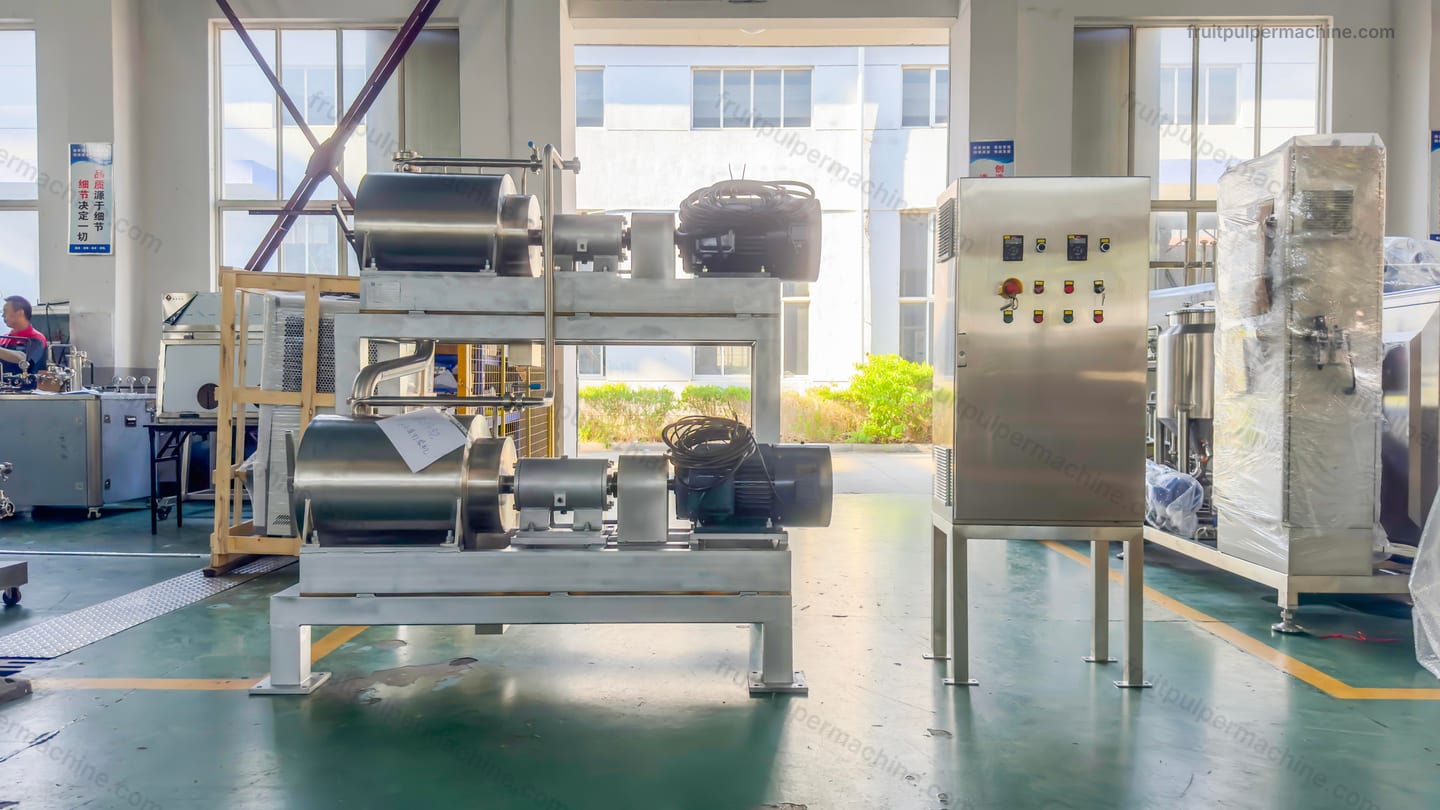Fruit pulper assembly beside its control cabinet and surrounding line interfaces