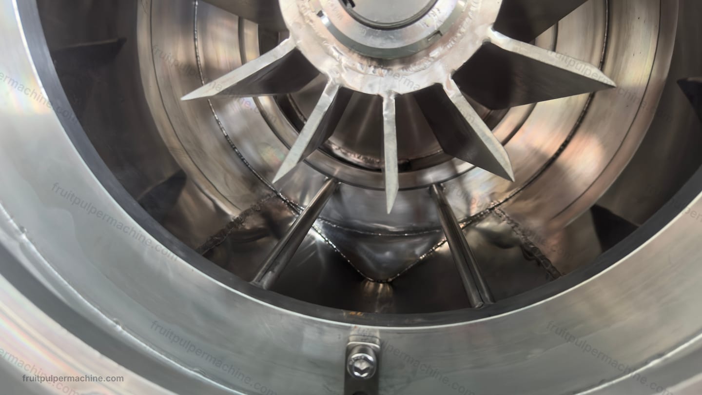 Fruit pulper open-chamber access Open stainless fruit pulper chamber exposing rotor surfaces for access review